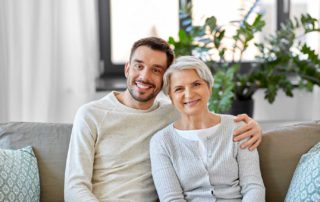 elderly woman with adult family member smiling